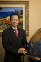 Dr. Ming Wang standing beside a globe王医师站在地球仪边上