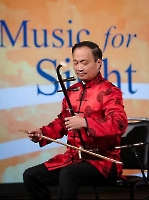 Dr. Wang playing the erhu (Chinese violin). 王医师和他的二胡